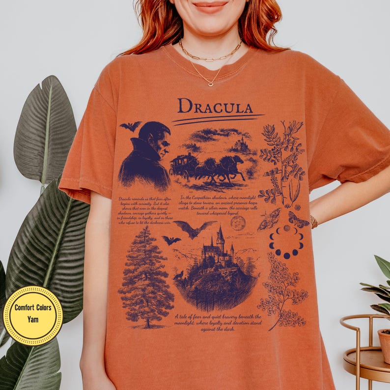 Op de afbeelding: Oranje Comfort Colors T-shirt met een donkerblauwe grafische print. Het ontwerp toont het woord "DRACULA", een vampier, een koets, een kasteel en tekst. Het T-shirt heeft een relaxte pasvorm.