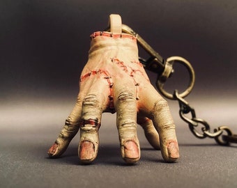 Creepy Stitched Hand Keychain  This eerie keychain features a severed hand with lifelike stitches and a decayed appearance