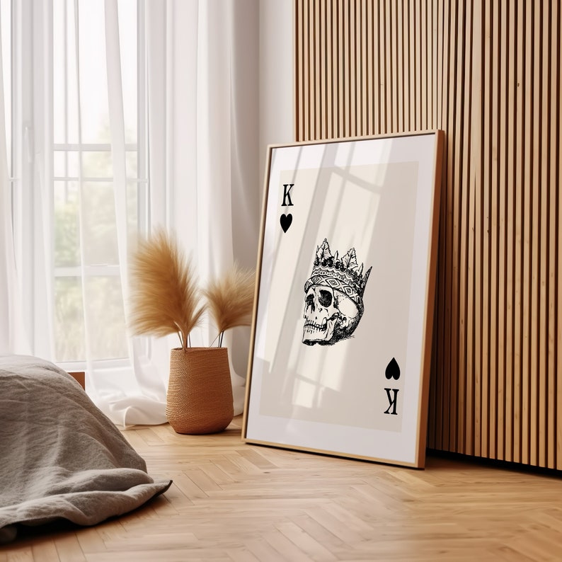 May include: A framed print of a playing card with a skull wearing a crown. The card is the King of Hearts.