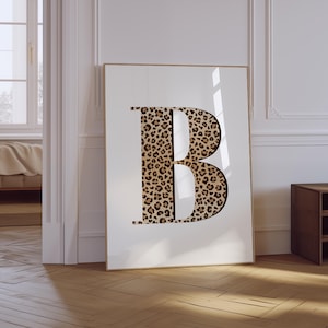 May include: A white framed poster with a large letter "B" printed in a leopard print pattern.