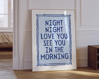 May include: A framed print with the words "NIGHT NIGHT LOVE YOU SEE YOU IN THE MORNING" in dark blue on a light blue background. The print is in a gold frame and leans against a white wall.