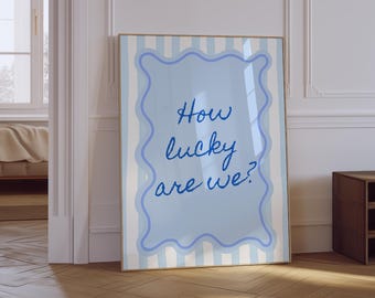 May include: A blue and white striped poster with a light blue frame and the text "How lucky are we?" in blue cursive writing.