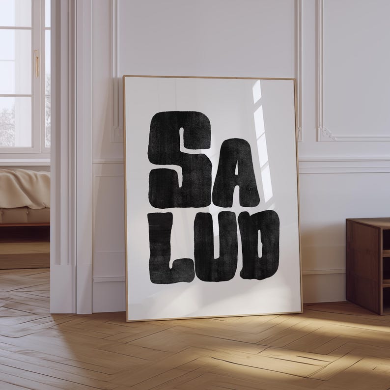 Op de afbeelding: Zwart-witte poster met het woord "SALUD" in vetgedrukte blokletters.