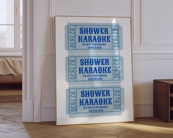May include: A framed print featuring three blue and white ticket stubs with the words "SHOWER KARAOKE" and "THE BEST PERFORMANCE HAPPENS HERE." The print is displayed in a room with hardwood floors and white walls.
