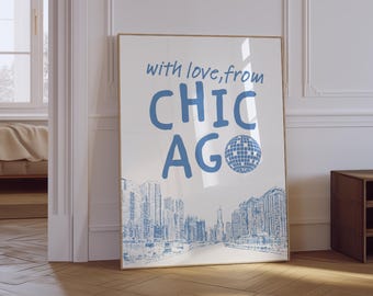 May include: A framed art print featuring the text "with love, from CHICAGO" in blue, with a cityscape illustration below. The print includes a blue disco ball graphic and is displayed on a wooden floor.