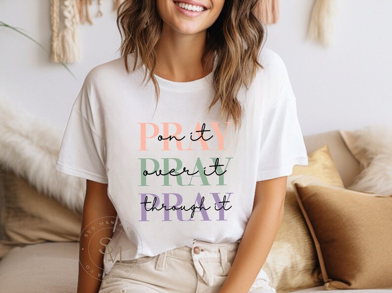May include: White t-shirt with the text "Pray on it, Pray over it, Pray through it" in colorful lettering.