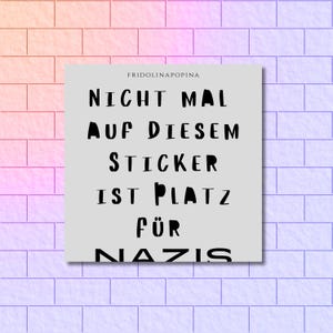 Puede incluir: Una pegatina cuadrada con el texto "NICHT MAL AUF DIESEM STICKER IST PLATZ FÜR NAZIS" en negro, fuente sans-serif. La pegatina está sobre un fondo gris claro, con el nombre "FRIDOLINAPOPINA" encima del texto. El fondo es una pared de ladrillos con un degradado rosa y morado.
