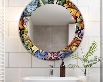 May include: A round decorative mirror with a colorful floral design border. The border features a black background with swirling patterns in shades of blue, yellow, orange, and purple. The mirror is mounted above a white sink.