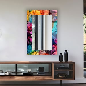 May include: A rectangular mirror with a colorful abstract design frame. The frame features swirls of pink, blue, yellow, green, and purple.