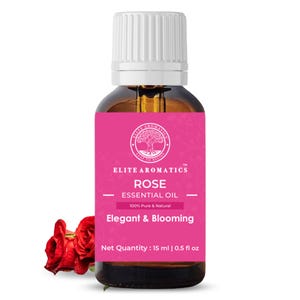 May include: A brown glass bottle of rose essential oil with a white cap and a pink label. The label reads "ELITE AROMATICS ROSE ESSENTIAL OIL" and "Elegant & Blooming." A red rose is visible in the lower left corner. The bottle contains 0.5 fl oz.