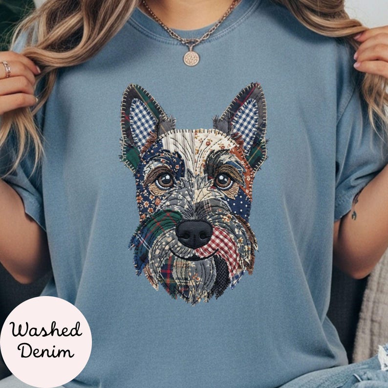 May include: A light blue t-shirt with a patchwork design of a Scottish Terrier dog. The dog's face is made of various fabric patterns, including plaid and floral prints. The text "Washed Denim" is printed on the bottom left of the shirt.