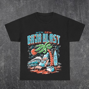 May include: Black t-shirt with a colorful graphic featuring the text "MTN DEW BAJA BLAST". The design includes a beach scene with a palm tree, a surfboard, and a soda bottle relaxing in a beach chair.