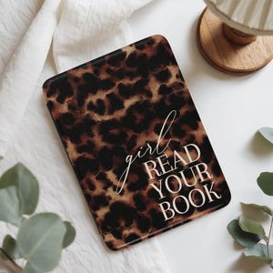 Op de afbeelding: Een rechthoekige e-reader hoes met een luipaardprint in bruin- en zwarttinten. De hoes heeft de woorden "girl READ YOUR BOOK" in witte letters en blokletters.