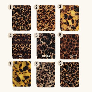 May include: Nine rectangular cases with a tortoiseshell pattern in shades of brown and tan. Some cases have initials or names in gold lettering, including "SL", "CK", "AT", and "Kelly".