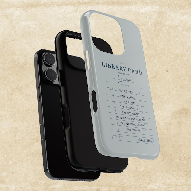 May include: A black smartphone with a protective case featuring a light blue library card design. The card lists book titles and the name "Laura". The phone case is a stylish accessory.