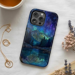 Op de afbeelding: Smartphonehoesje met een landschapsontwerp met bergen, bomen en een meer onder een sterrenhemel. De hoes heeft een donkerblauw en blauwgroen kleurenschema, met een glanzende afwerking. De hoes is ontworpen voor een smartphone.