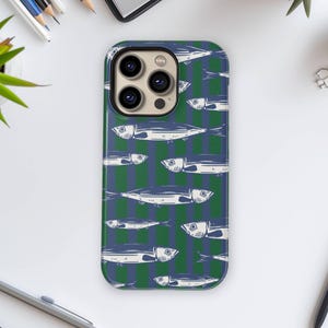 Könnte beinhalten: Eine Handyhülle mit einem sich wiederholenden Muster aus weißen Fischen auf einem grün-blauen gestreiften Hintergrund. Die Hülle hat eine glänzende Oberfläche und einen Kameraausschnitt.