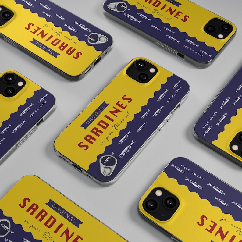May include: Yellow and navy blue phone cases with a sardine can design. The cases feature the text "ORIGINAL SARDINES in pure Olive oil" in red and white. The design includes illustrations of sardines and the text "NET WT. 3.75oz".