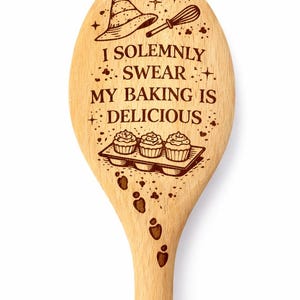 May include: Wooden spoon with engraved text: "I solemnly swear my baking is delicious." Features a witch's hat, whisk, cupcakes, and footprints. A charming kitchen utensil for baking enthusiasts.