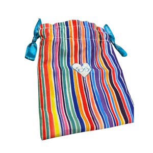 May include: A drawstring bag with vertical stripes in various colors, including red, orange, yellow, green, blue, purple, and white. The bag has a white heart-shaped emblem with a stylized letter "B" and is tied with turquoise ribbons.