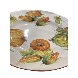 May include: A decorative ceramic serving platter with a painted harvest theme. The design features pumpkins, squash, and ears of corn in shades of orange, yellow, and green, with brown trim. The platter is ideal for fall gatherings.