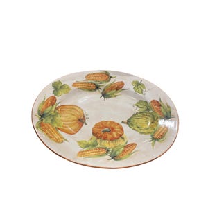 May include: Oval ceramic serving platter with a hand-painted harvest design. The platter features images of pumpkins, gourds, and corn on the cob in shades of orange, yellow, and green. The rim has a brown border.