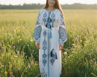 Vestido blanco de lino bordado con motivos grises y azules, estilo bohemio.