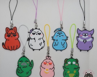 Puede incluir: Ocho abalorios de teléfono de personajes de dibujos animados coloridos con lazos de cuerda negros. Los personajes incluyen un gato rojo, un diablo blanco, un pájaro azul, un monstruo morado, un pájaro verde, un pájaro rosa y dos ranas verdes.
