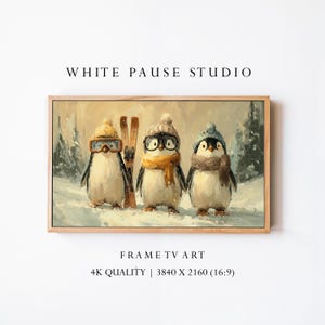 Könnte beinhalten: Gerahmter Druck mit drei Pinguinen in Winterkleidung. Die Pinguine tragen Mützen, Schals und Brillen, mit Skiern im Hintergrund. Das Kunstwerk trägt die Aufschrift "WHITE PAUSE STUDIO" und "FRAME TV ART".