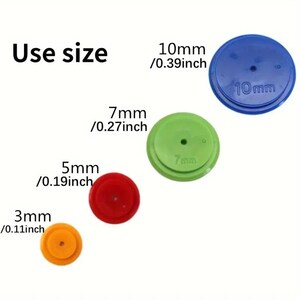 Könnte beinhalten: Vier runde Kunststoffscheiben in verschiedenen Größen und Farben. Die Scheiben sind mit ihrem Durchmesser in Millimetern und Zoll beschriftet. Die Scheiben sind 3 mm / 0,11 Zoll, 5 mm / 0,19 Zoll, 7 mm / 0,27 Zoll und 10 mm / 0,39 Zoll. Die Scheiben sind blau, grün, rot und orange.