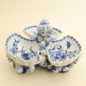 William Duesbury Derby ca. 1765 Blauw-witte schaal in schelpvorm voor zoetwaren, met vlekken.
