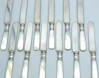 Set di 12 coltelli da colazione con collarino in argento e manico in madreperla, lunghezza circa 20 cm.