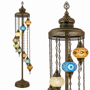 May include: A bronze-colored floor lamp with multiple hanging mosaic glass globes in various colors. The lamp has an ornate, decorative design with a circular base and a tall central pole. The globes are illuminated, creating a warm, inviting glow.