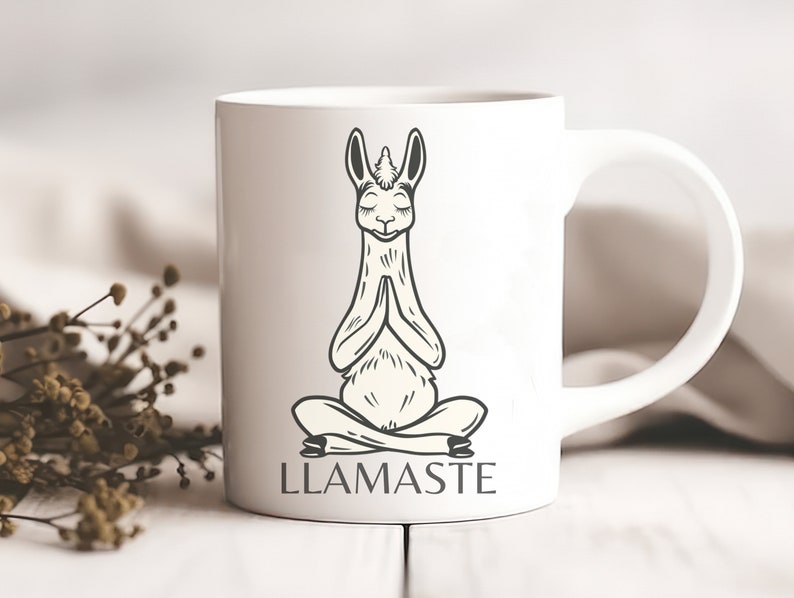 May include: White ceramic mug with a black and white illustration of a llama in a yoga pose. The text "LLAMASTE" is printed below the llama.