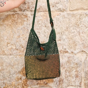 May include: A green and brown crocheted tote bag with a leather handle. The bag is made of a mesh material and has a gradient design.