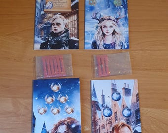 May include: Four illustrated cards featuring characters from the Harry Potter series. The cards are set against a snowy background with a blue and white color scheme. The first card features a young man with brown hair and a scarf. The second card features a young woman with long blonde hair and a crown of antlers. The third card features a young woman with long red hair and a blue and white background. The fourth card features an older man with gray hair and a blue and white background.