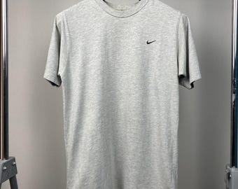 Camisa Nike gris vintage de los 90 · Logotipo Swoosh bordado · Camiseta de manga corta con cuello redondo · Nike vintage de EE. UU. · Ropa deportiva Nike de segunda mano ·