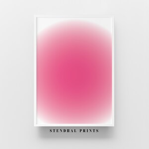 Puede incluir: Una impresión enmarcada con un círculo degradado rosa en el centro. La impresión está sobre un fondo blanco y tiene un marco blanco. El texto "STENDHAL PRINTS" está impreso debajo del marco.