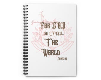 Op de afbeelding: Witte spiraalgebonden notitieboek met de tekst "For God So Loved The World" in bruine, gestileerde letters. Het ontwerp bevat een kruis, bloemmotieven en de Bijbelverwijzing Johannes 3:16.