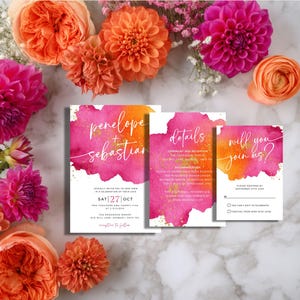 May include: Wedding invitation suite with watercolor design in shades of pink and orange. The invitation cards include the names "Penelope + Sebastian", details, and a response card. Floral arrangement of pink and orange flowers surrounds the cards.