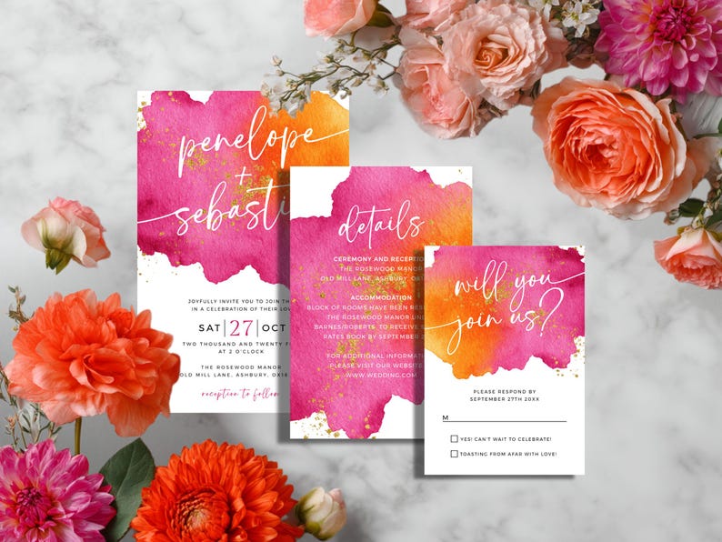 May include: Wedding invitation suite with watercolor design. The set includes an invitation, details card, and RSVP card. The cards feature pink and orange watercolor backgrounds with gold accents and elegant script. Floral arrangement in the background.