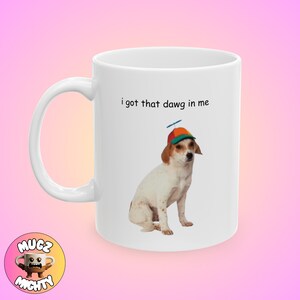 Op de afbeelding: Witte keramische mok met een witte hond die een kleurrijke hoed draagt en de tekst "i got that dawg in me".