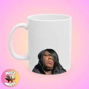 May include: White ceramic mug featuring a black and white image of a person with long black hair. The person is looking to the right of the image.