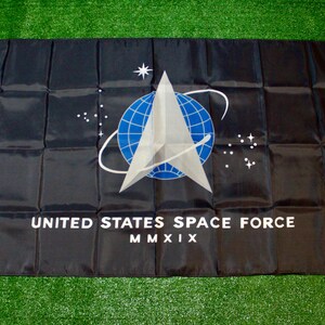May include: A black flag with the United States Space Force logo. The logo is a silver delta with a blue globe inside, surrounded by a silver orbit. The text "UNITED STATES SPACE FORCE" and "MMXIX" is printed below the logo.