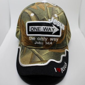 Puede incluir: Gorra de béisbol de camuflaje con el texto "ONE WAY" y "the only way John 14:6". La gorra también presenta la palabra "Jesus" y "I ❤️ Jesus" bordadas en blanco y rojo.