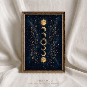 May include: A framed vertical wall art print featuring a dark navy blue night sky background with a central column of golden moon phases. Two symmetrical golden floral vines frame the moons, surrounded by scattered stars and the text NORDHOLM.
