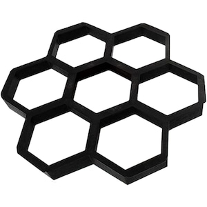 Puede incluir: Molde de plástico negro para hacer adoquines de hormigón. El molde tiene forma de panal de abeja con seis secciones hexagonales.