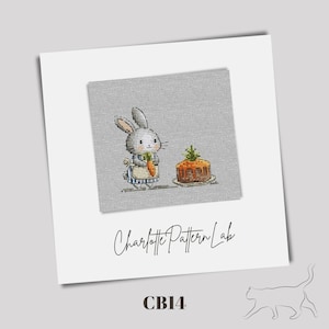 Könnte beinhalten: Ein Kreuzstichmuster mit einem grauen Hasen, der eine Karotte hält und neben einem braunen Kuchen mit grünem Frosting steht. Das Muster ist auf einem grauen Leinenhintergrund und enthält den Text "Charlotte Pattern Lab" und "CB14".