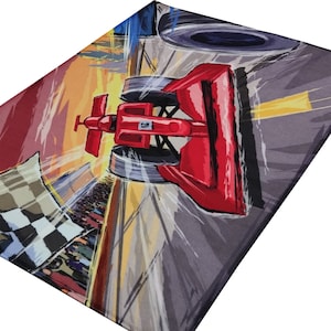 May include: A red race car speeding down a track with a checkered flag waving in the background. The car is painted red with a black number "12" on the side. The track is gray with yellow lines and a blurred background of a crowd of people.