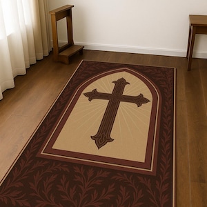 May include: A rectangular rug with a large brown cross design in the center, set against a beige background with radiating lines. The rug has a dark brown border with a repeating leaf pattern.